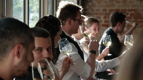 People tasting wine at an indoor event.