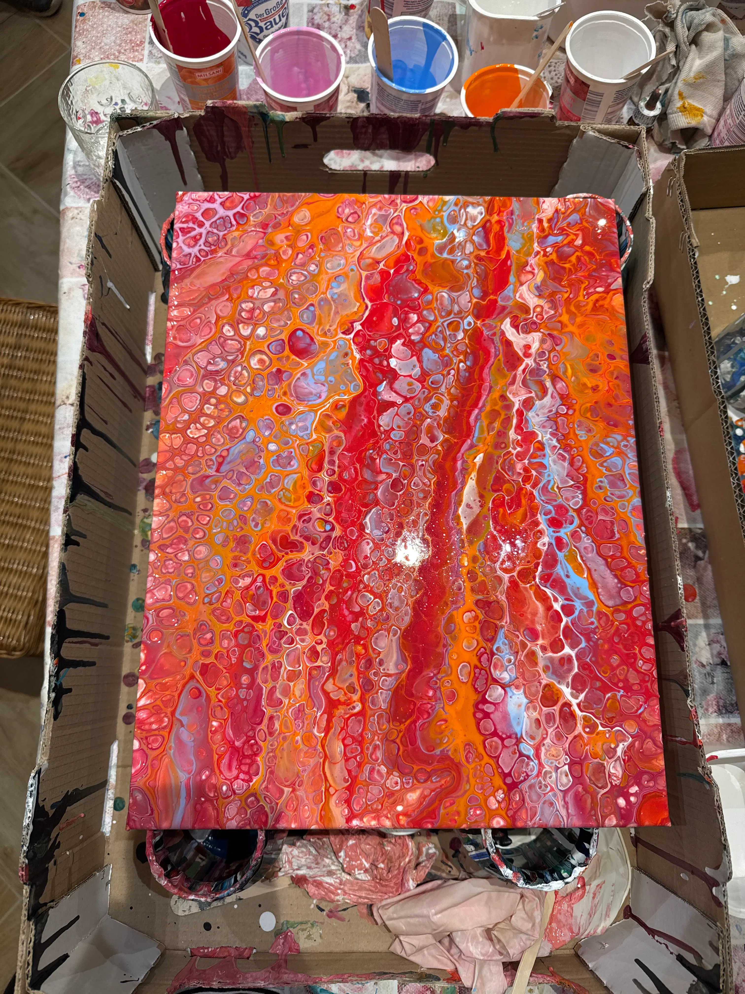 Abstraktes Gemälde mit roten und orangenen Acrylfarben.