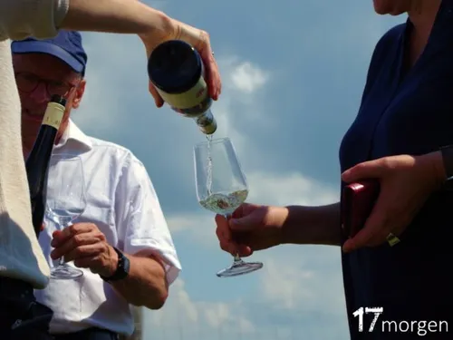 Glas wird mit Wein unter blauem Himmel gefüllt.