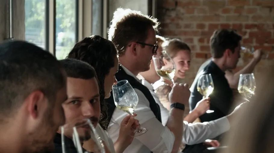 People tasting wine in a restaurant setting.