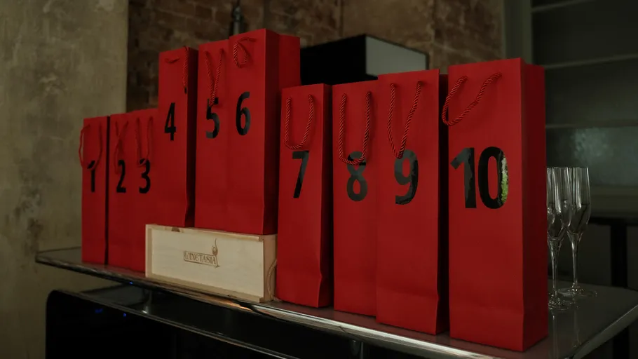 Red gift bags numbered on a table.