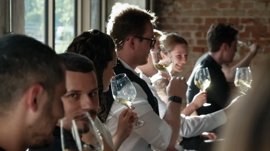Gruppe Menschen verkostet Wein im Sonnenlicht.