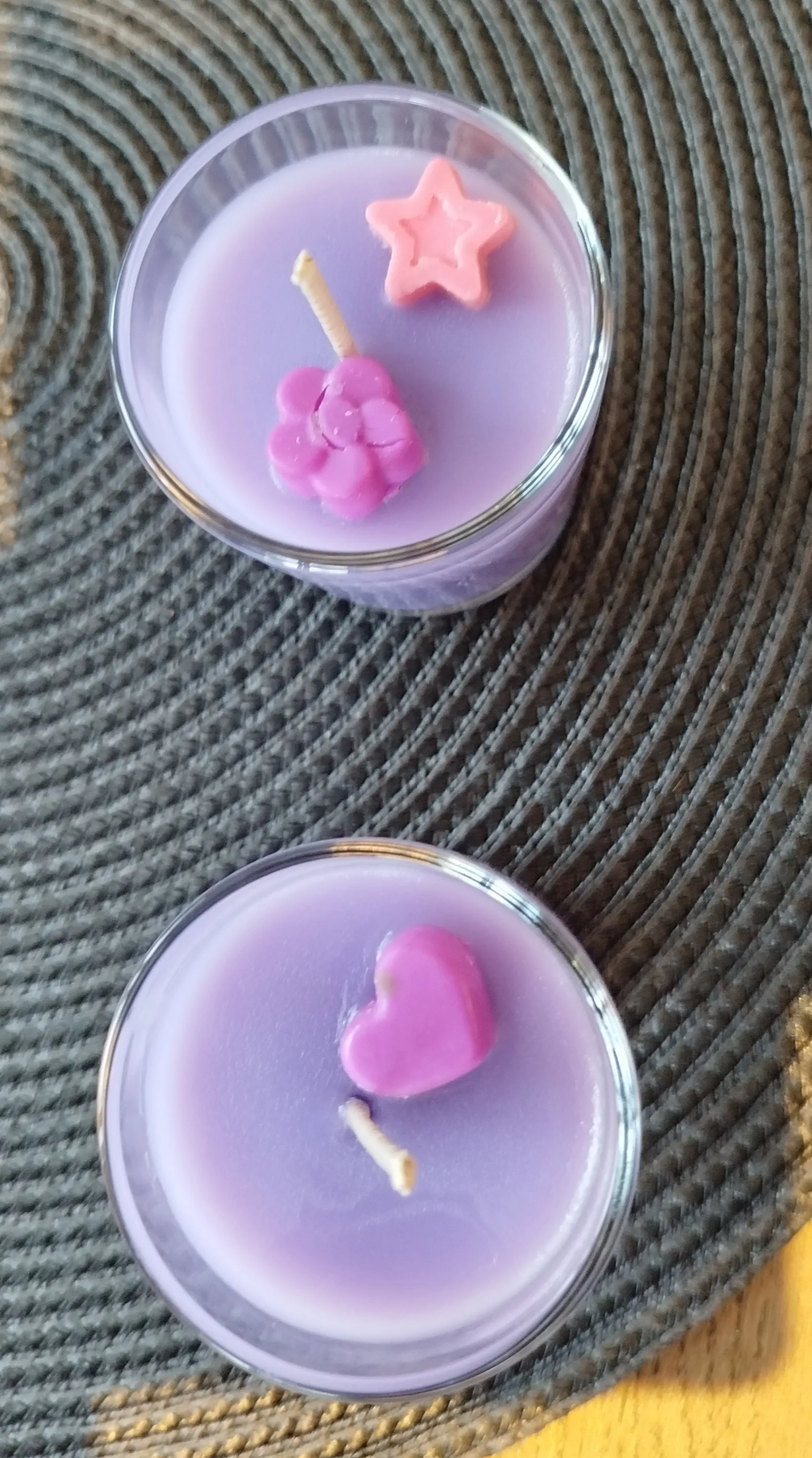 Zwei violette Kerzen mit dekorativen Formen.