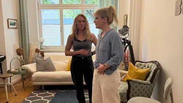 Two women talking in a living room.