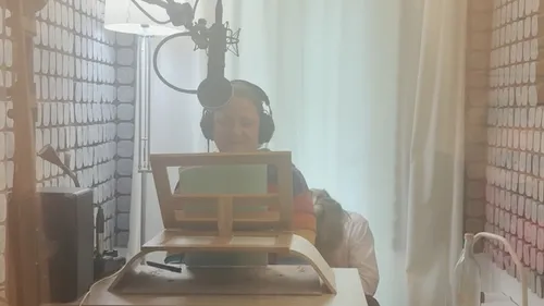 Person recording with microphone in soundproof room.