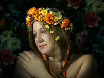 Frau mit Blumenkranz betrachtet nachdenklich bunten Hintergrund.