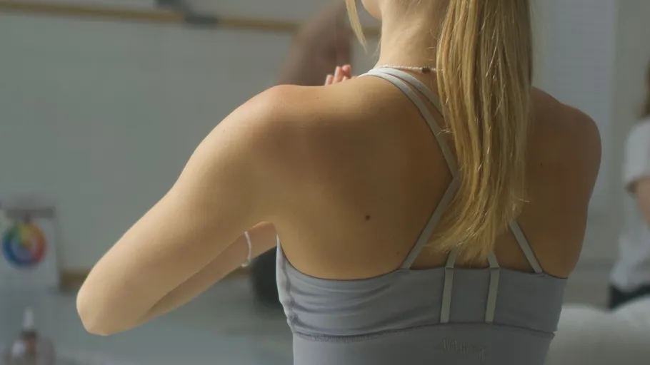 Woman practicing yoga indoors, hands in prayer.