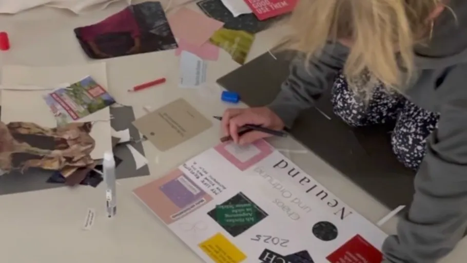 Person creating collage with various colored papers.