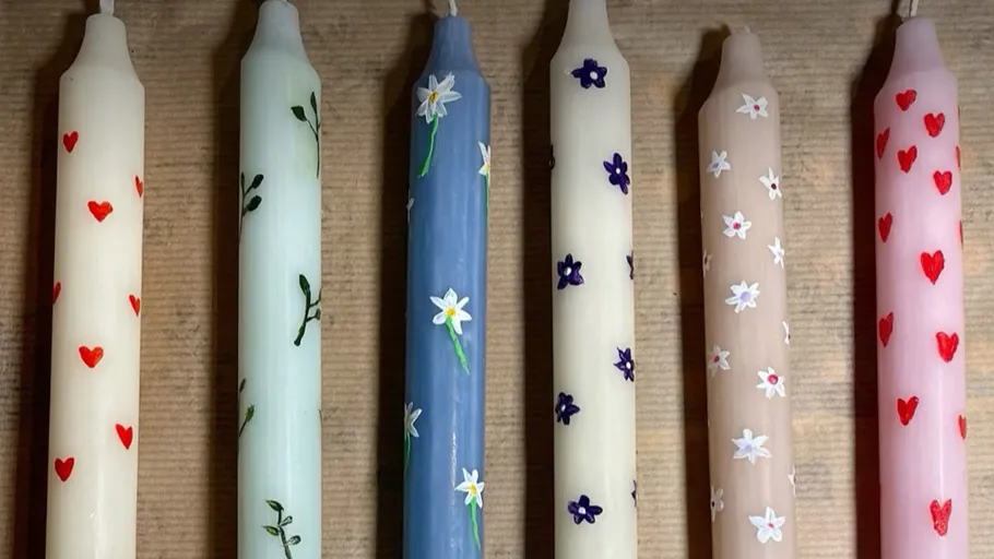 Sechs dekorative Kerzen mit bunten Mustern.