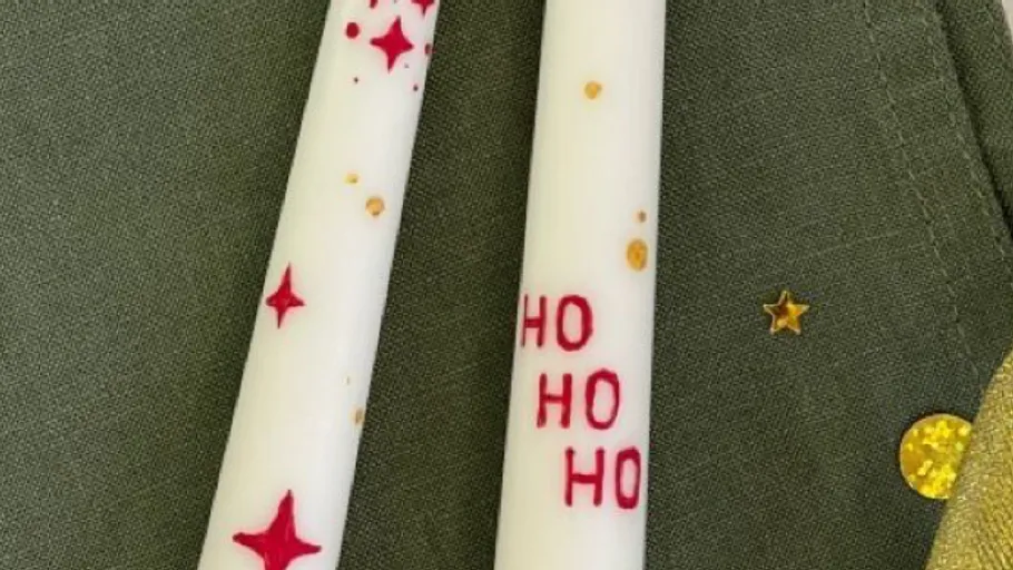 Two decorated candles on green background.