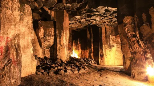 Schwach beleuchtete Höhle mit Steinsäulen.