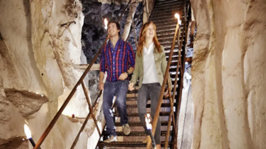 Couple walking down stairs in a cave.