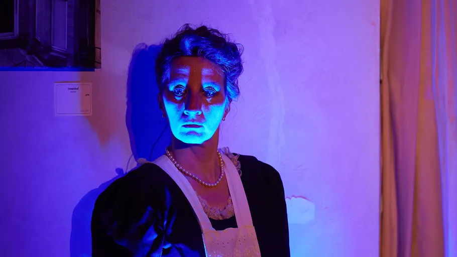 Frau im blauen Licht, weit geöffnete Augen, drinnen.