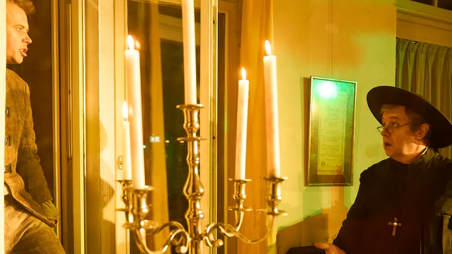 Two people in room with candles.