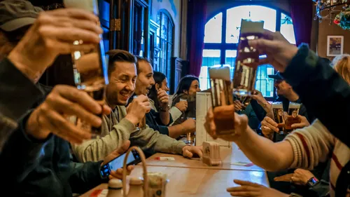People clinking glasses in a cozy pub.