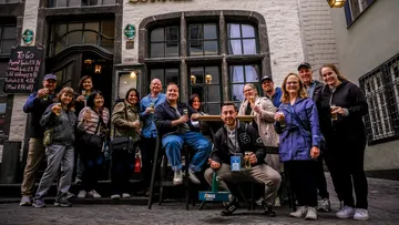 Gruppe genießt Getränke vor historischem Pub.