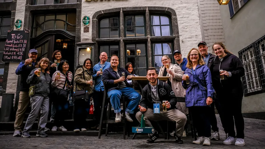 Gruppe genießt Getränke vor historischem Pub.