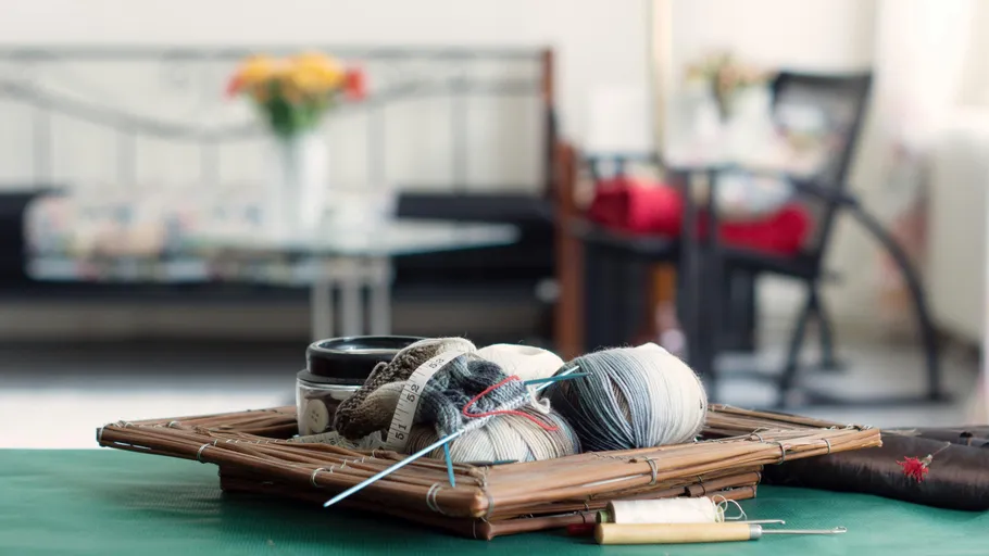 Yarn and needles on a table, cozy living room.