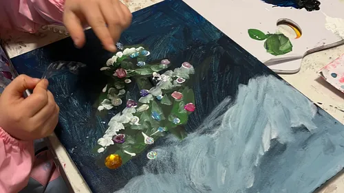 Child painting colorful flowers on canvas.