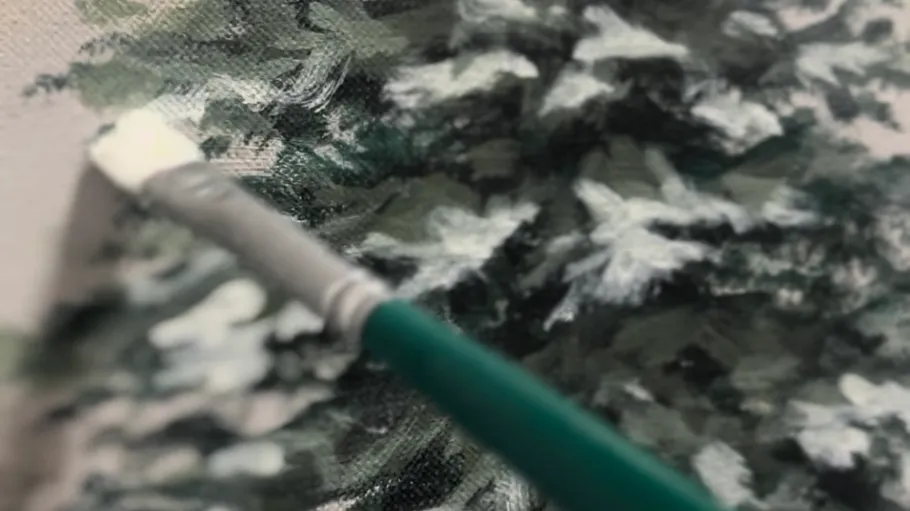 Paintbrush painting trees on a canvas.