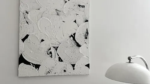 Abstract black and white painting near lamp.