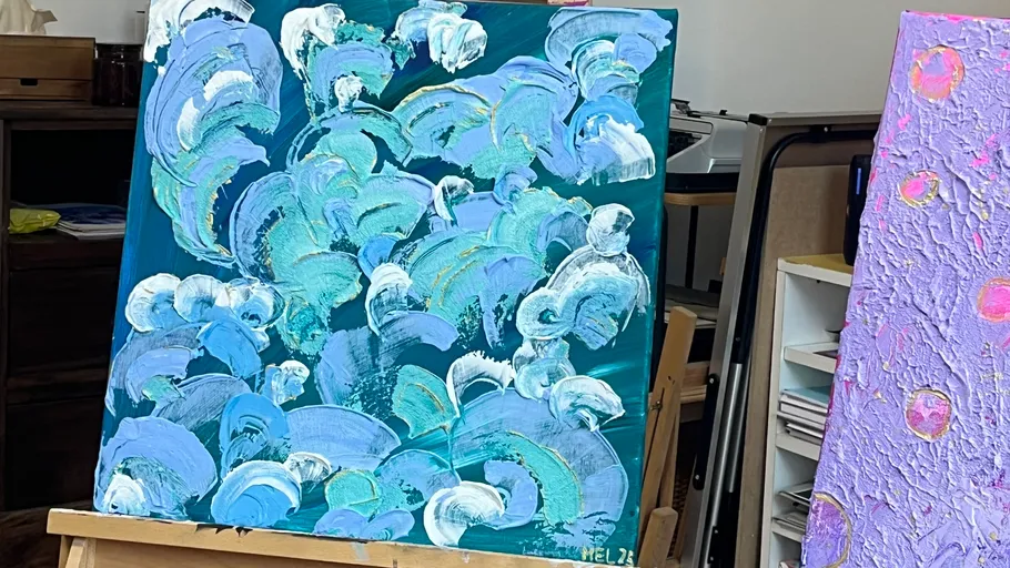 Abstract painting of ocean waves on easel.