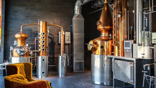 Copper distillery equipment in modern interior.