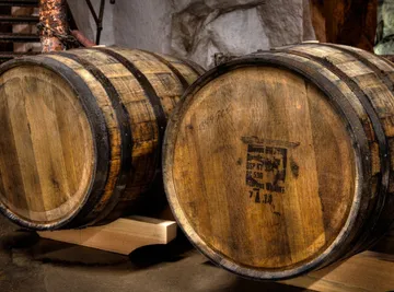 Wooden barrels resting in a cellar.