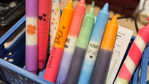 Bunte Kerzen in einem blauen Korb.