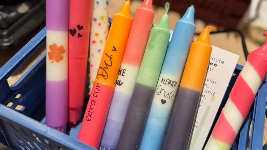 Colorful candles in a blue basket.