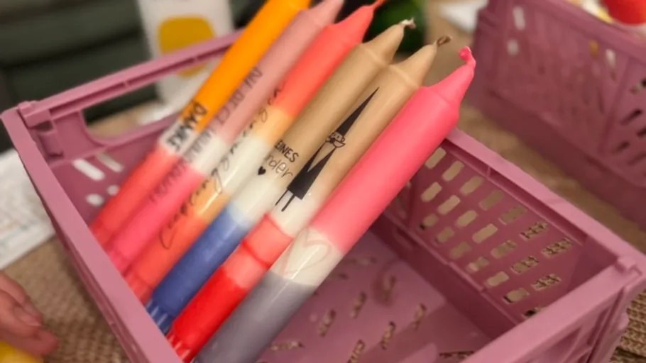 Colorful candles in a purple basket.