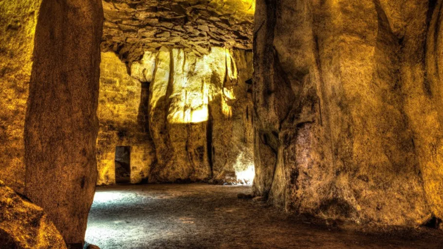 Ancient sandstone cave with pillar structures.