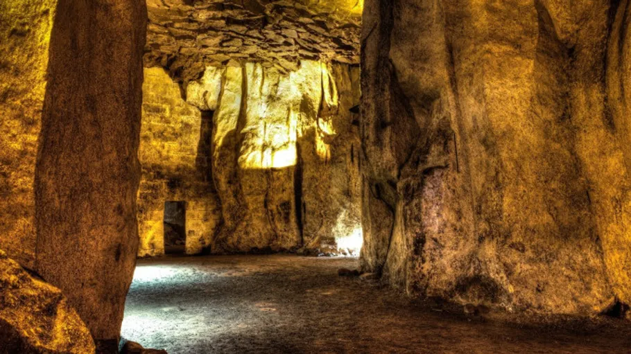 Large cave interior with illuminated walls.