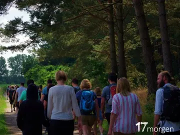Group of people wandering along a forest trail.