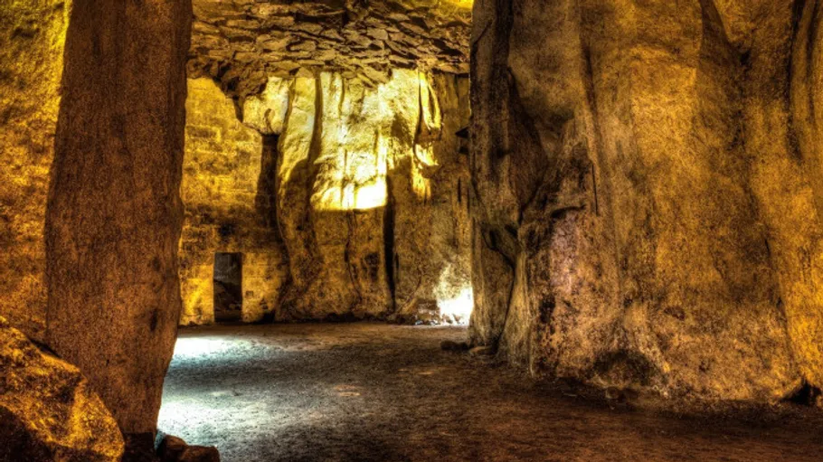 Large rocky cave with glowing yellow light.