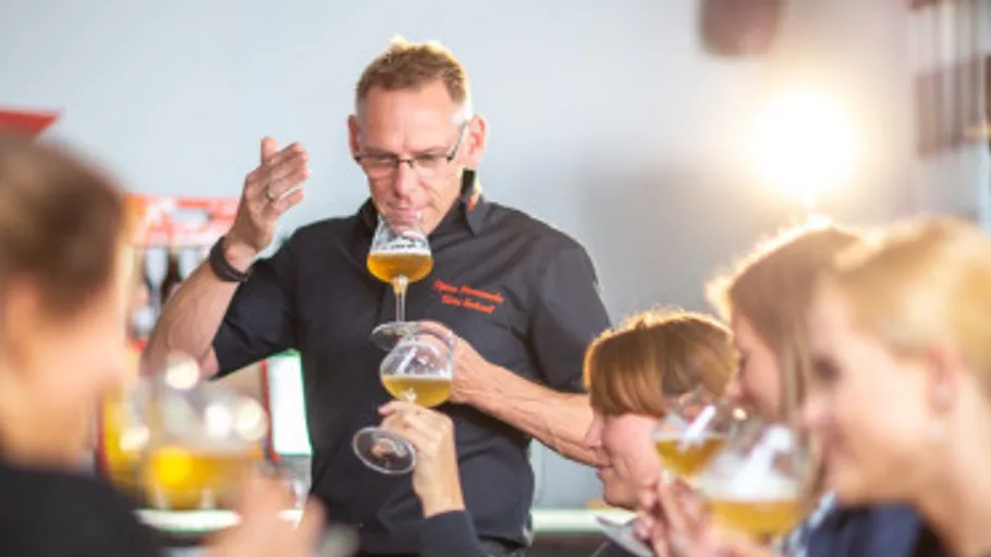 Mann leitet Bierverkostung mit Leuten im Hintergrund.