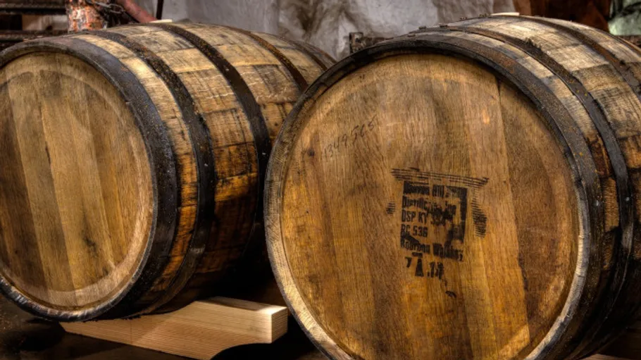 Wooden barrels resting in a rustic environment.