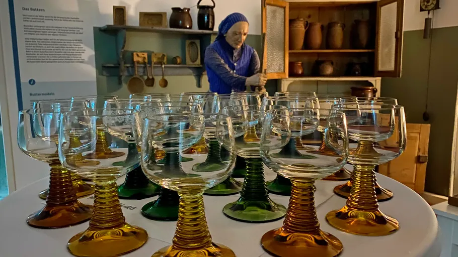 Colorful wine glasses on table, historical kitchen background.