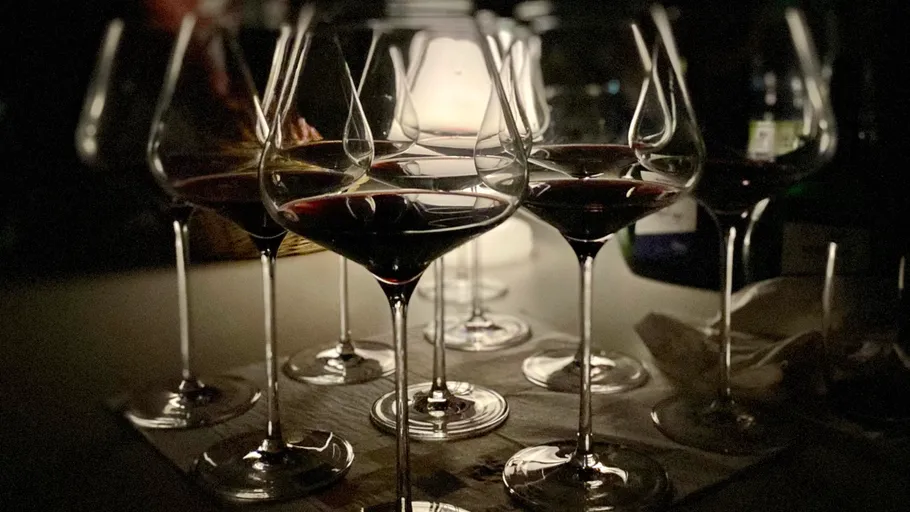 Wine glasses with red wine on table.