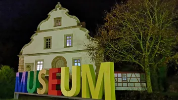 Large museum sign in front of building.
