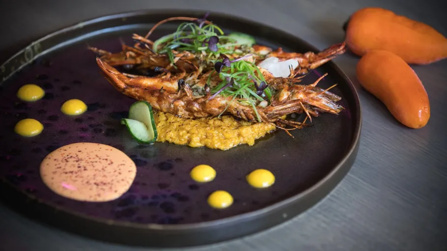 Gourmet shrimp plated artistically with sauces.