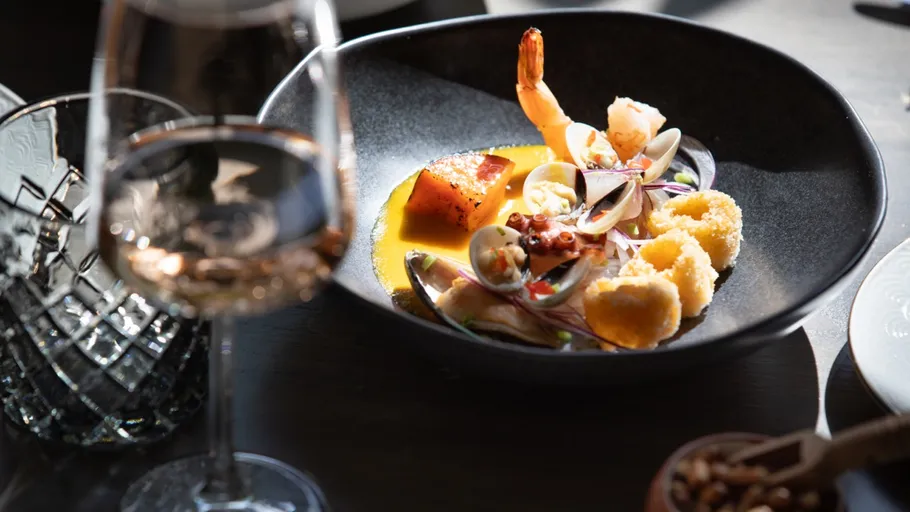 Gourmet seafood dish in elegant restaurant setting.