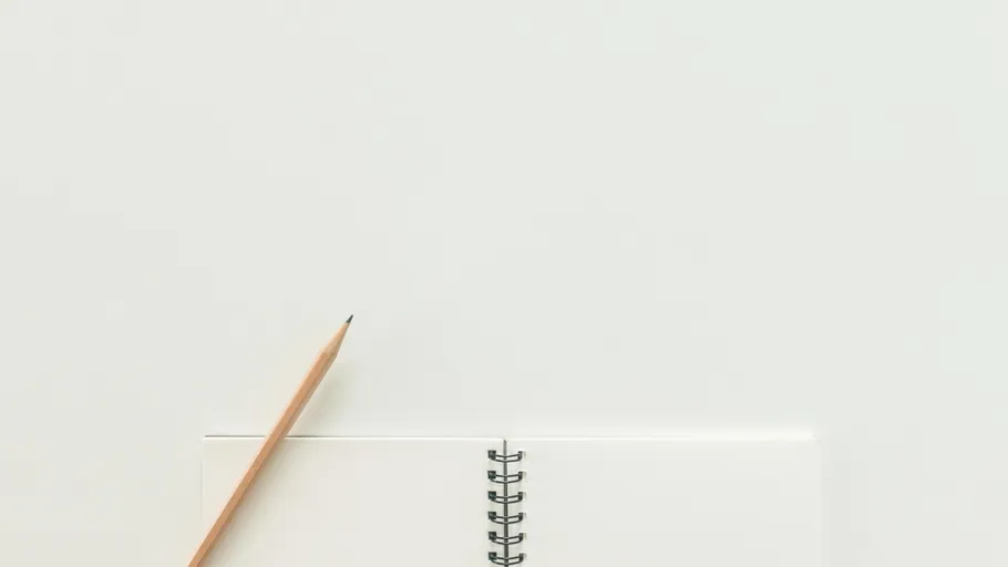 Pencil next to blank spiral notebook.