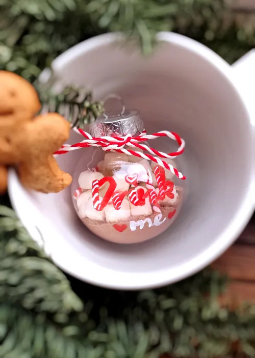 Ornament with cocoa and marshmallows in mug.