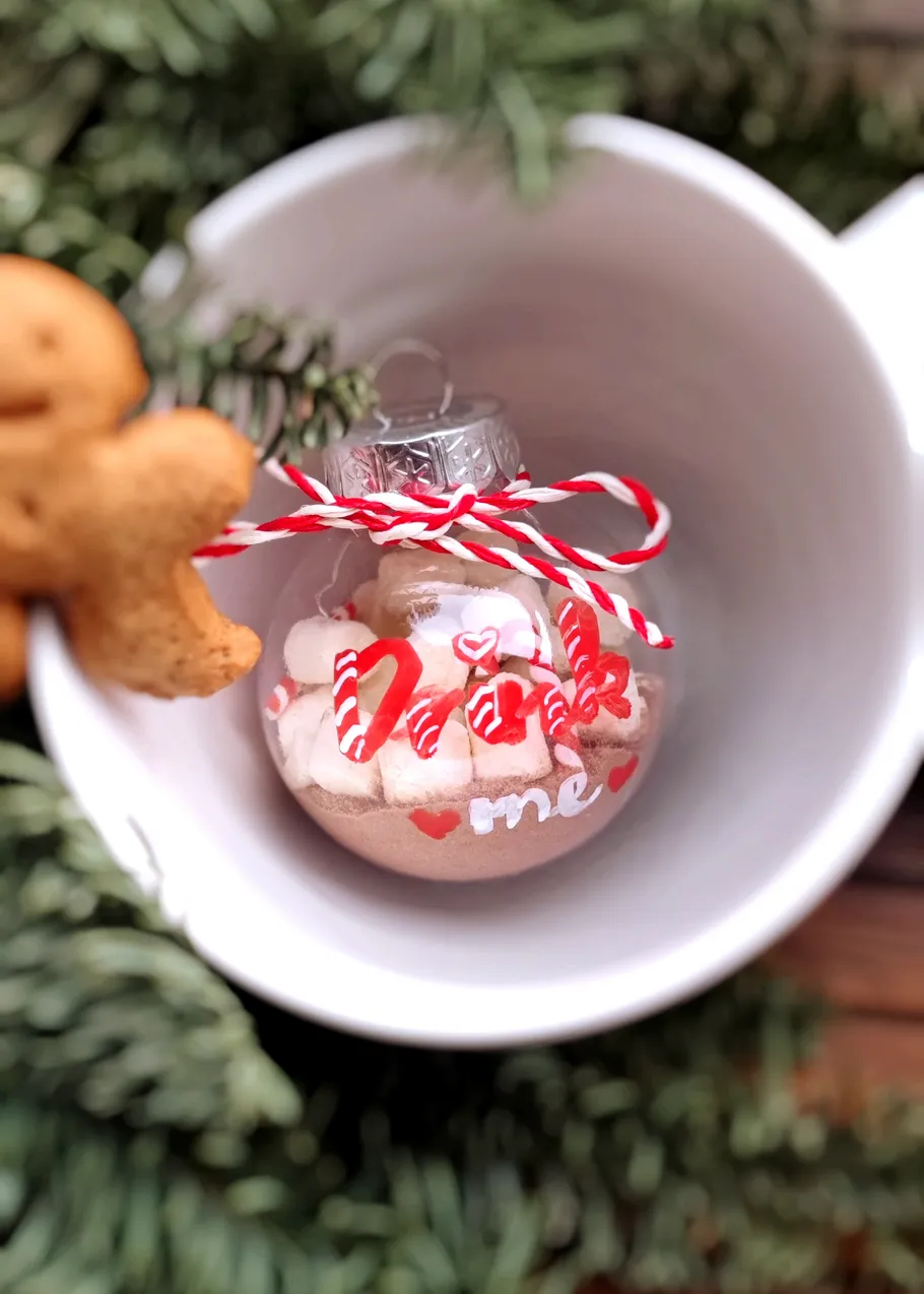 Ornament with cocoa and marshmallows in mug.