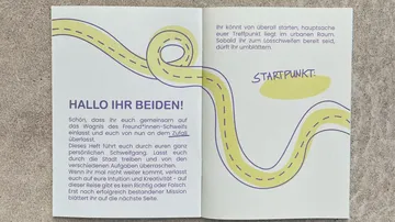 Open booklet with text and winding road design.