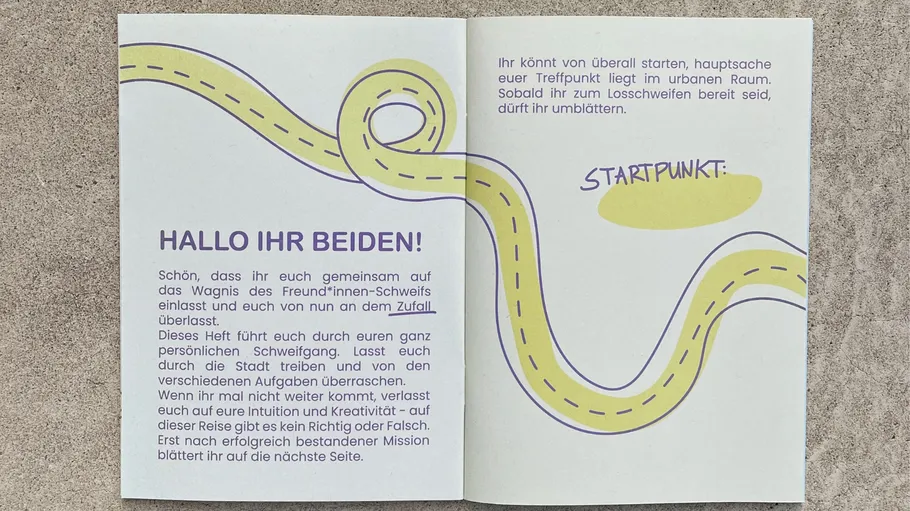 Offenes Heft mit Text und gewundener Straße.