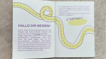 Offenes Buch mit deutschem Text und gewundener Straße.