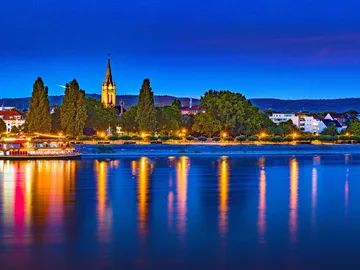 Nice city view with running water and illuminated buildings.