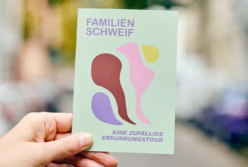 Hand hält abstrakte Kunstkarte im Freien.